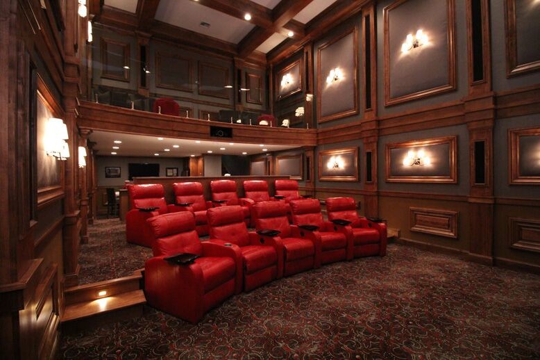 Idée de décoration pour une grande salle de cinéma fermée avec un mur gris, moquette, un écran de projection et un sol multicolore.