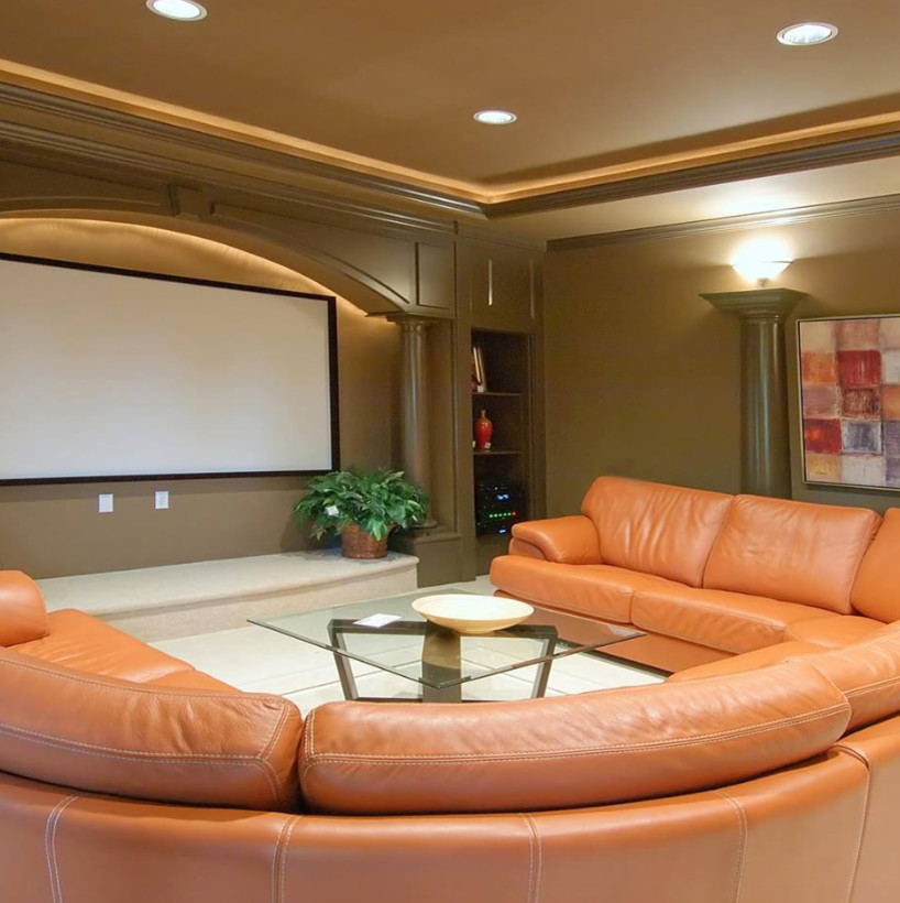 Modelo de cine en casa cerrado clásico grande con paredes beige, moqueta, pantalla de proyección y suelo beige