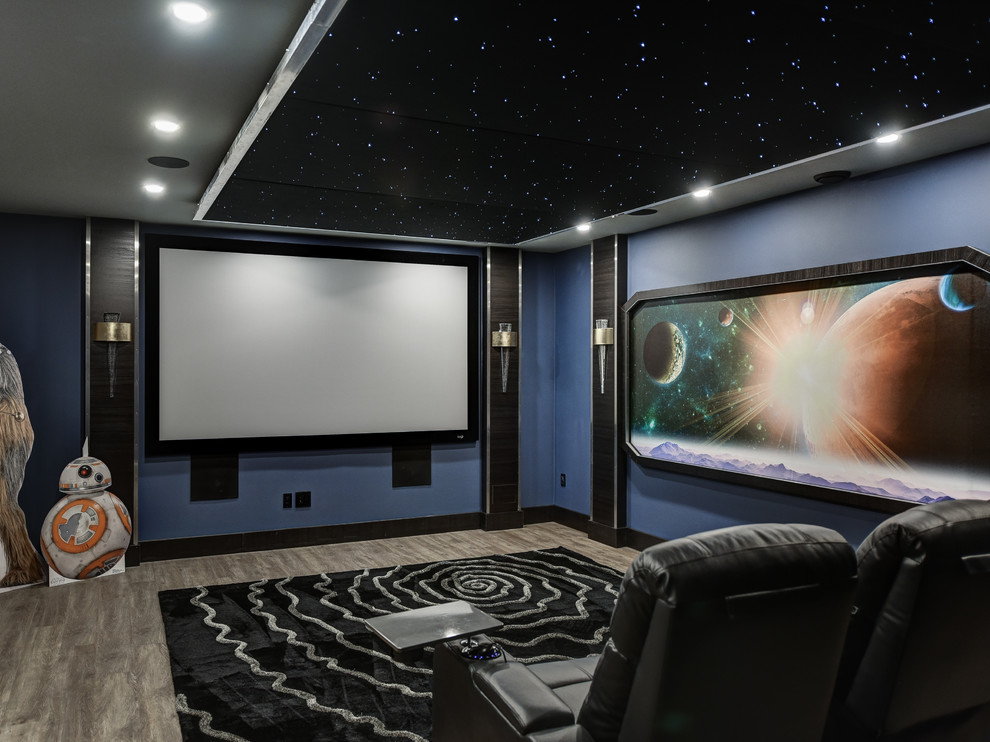 This is an example of a contemporary enclosed home cinema in Toronto with blue walls, medium hardwood flooring, a projector screen and brown floors.
