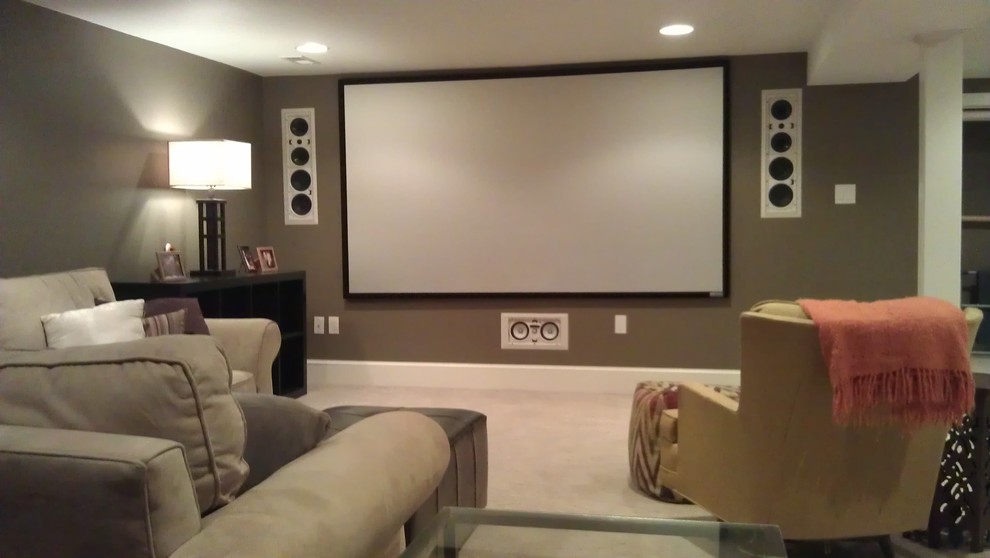 Large traditional open plan home cinema in Philadelphia with brown walls, carpet, a projector screen and beige floors.