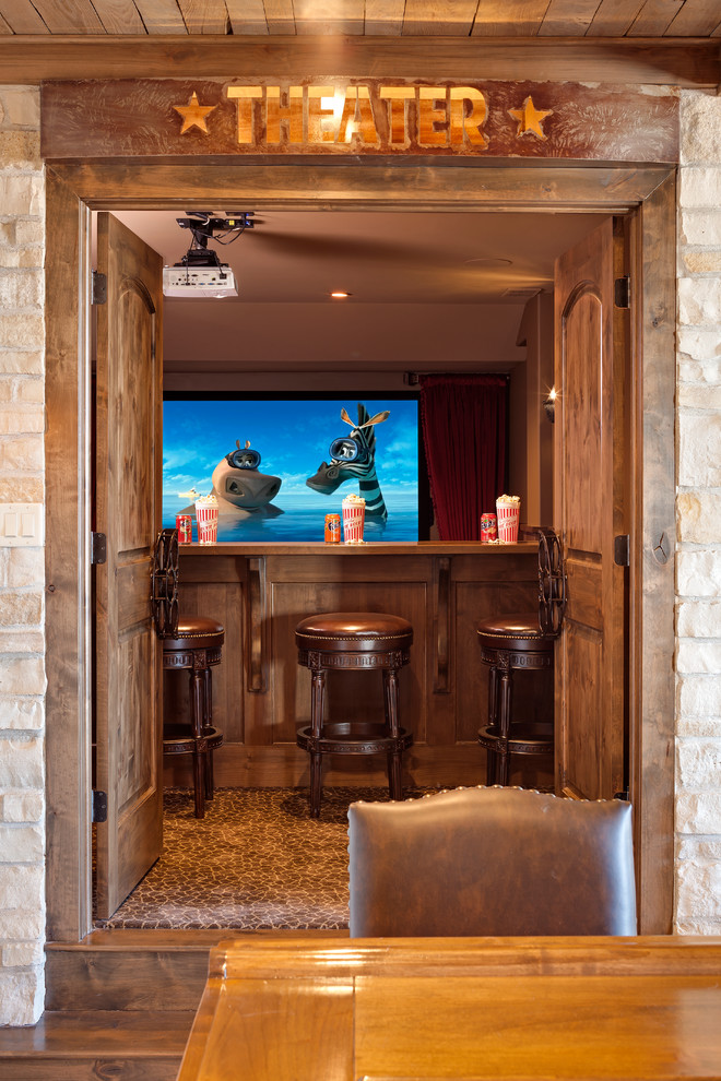 This is an example of a large rustic enclosed home cinema in Chicago with brown walls, carpet, a projector screen and multi-coloured floors.