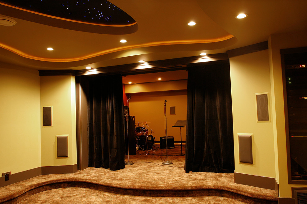 Стильный дизайн: большой изолированный домашний кинотеатр в современном стиле с разноцветными стенами, ковровым покрытием, проектором и коричневым полом - последний тренд