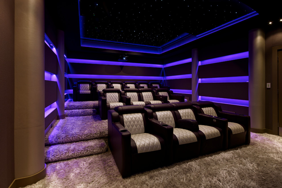 Cette image montre une salle de cinéma minimaliste de taille moyenne et fermée avec moquette, un sol beige, un mur violet et un téléviseur encastré.