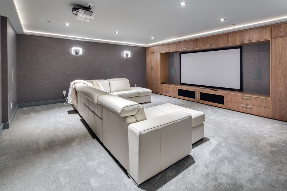 Ejemplo de cine en casa cerrado actual con paredes grises, moqueta, pantalla de proyección y suelo gris