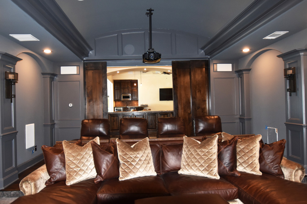 Large tuscan enclosed carpeted home theater photo in Houston with gray walls and a projector screen