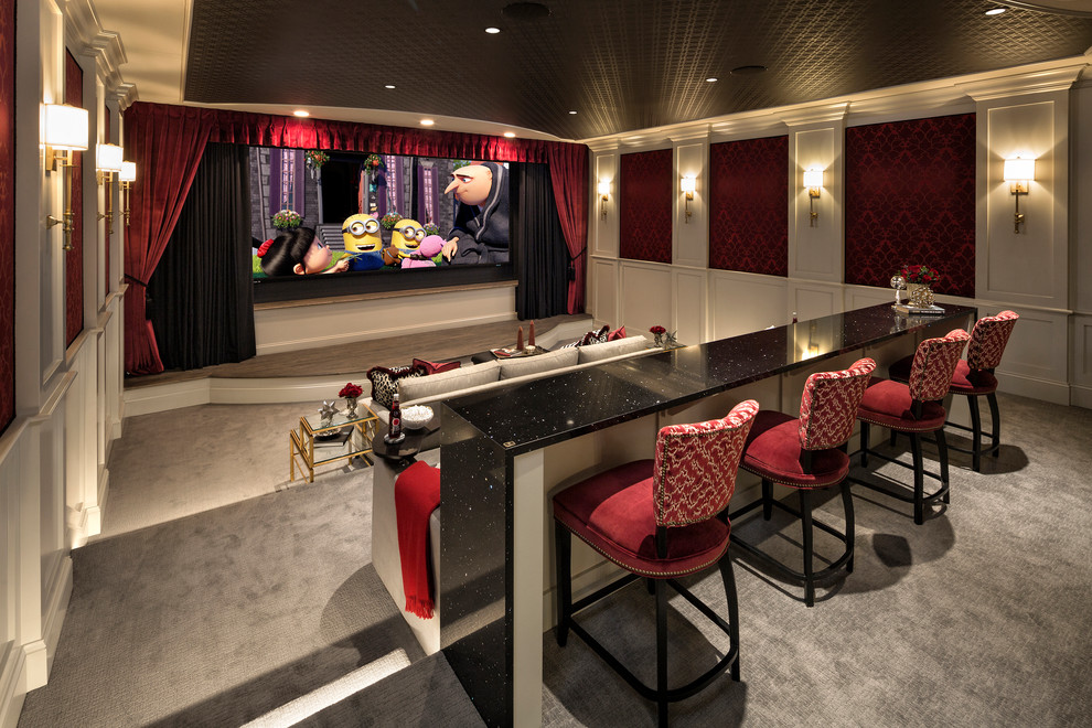 Стильный дизайн: огромный изолированный домашний кинотеатр в классическом стиле с красными стенами, ковровым покрытием, проектором и серым полом - последний тренд