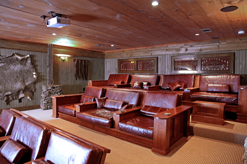 This is an example of a large rustic enclosed home cinema in Atlanta with brown walls, carpet and a projector screen.