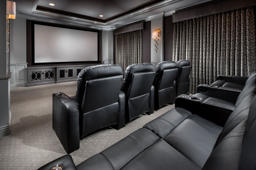 Cette image montre une salle de cinéma traditionnelle fermée avec un mur gris, moquette, un écran de projection et un sol gris.