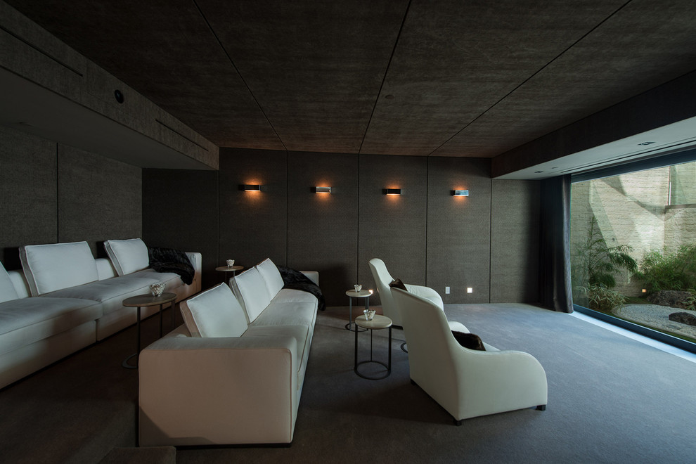 Idee per un ampio home theatre moderno aperto con moquette, schermo di proiezione, pareti marroni e pavimento grigio