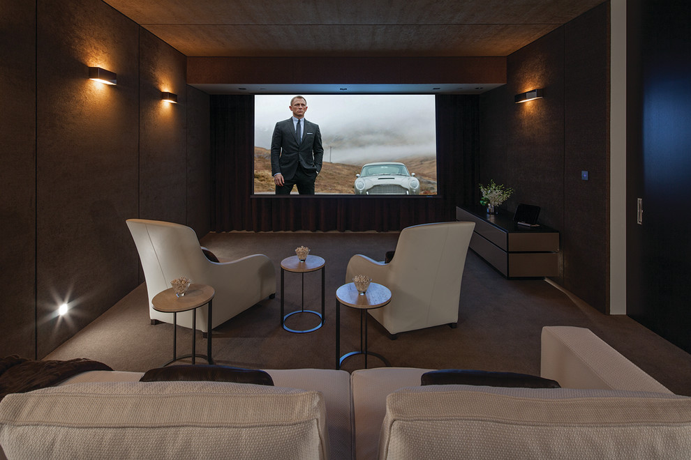 На фото: изолированный домашний кинотеатр среднего размера в стиле модернизм с коричневыми стенами, ковровым покрытием, проектором и серым полом с