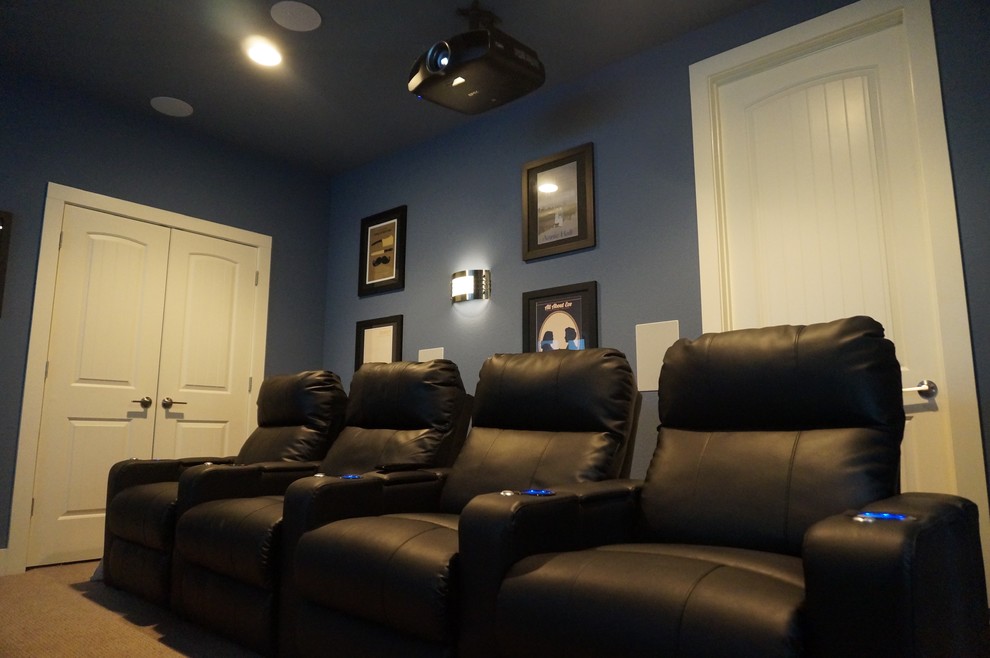 This is an example of a large traditional enclosed home cinema in Austin with blue walls, carpet and a projector screen.