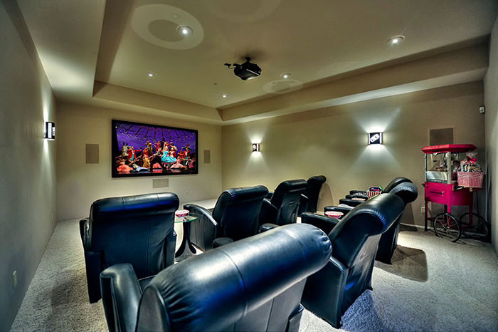 Home theater - huge mid-century modern open concept carpeted home theater idea in Phoenix with beige walls and a wall-mounted tv