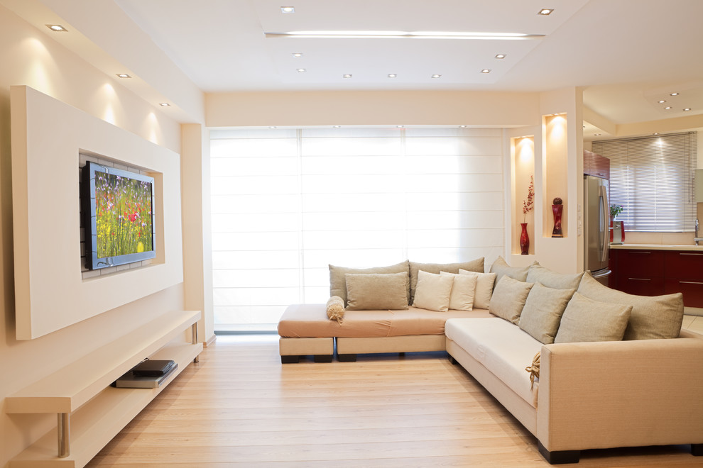 Modern inredning av ett mellanstort öppen hemmabio, med vita väggar, vinylgolv och en väggmonterad TV