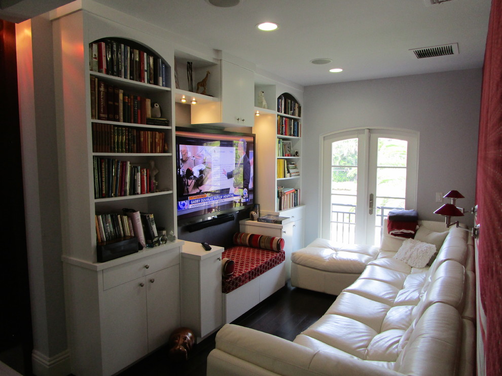 На фото: открытый домашний кинотеатр среднего размера в стиле фьюжн с белыми стенами, темным паркетным полом, телевизором на стене и коричневым полом с
