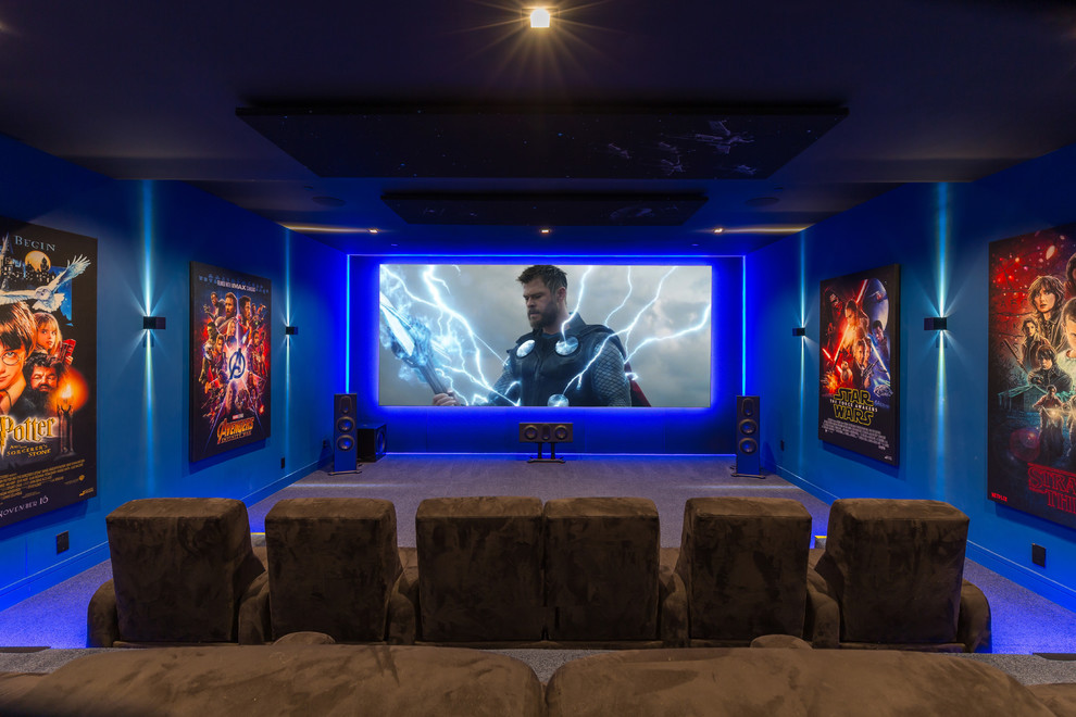 Imagen de cine en casa cerrado moderno extra grande con paredes azules, moqueta, pantalla de proyección y suelo gris
