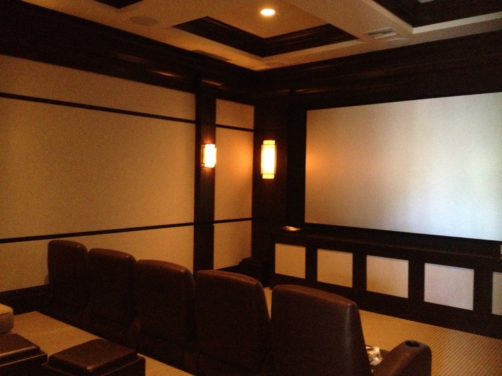 Immagine di un grande home theatre design chiuso con pareti bianche, moquette e schermo di proiezione