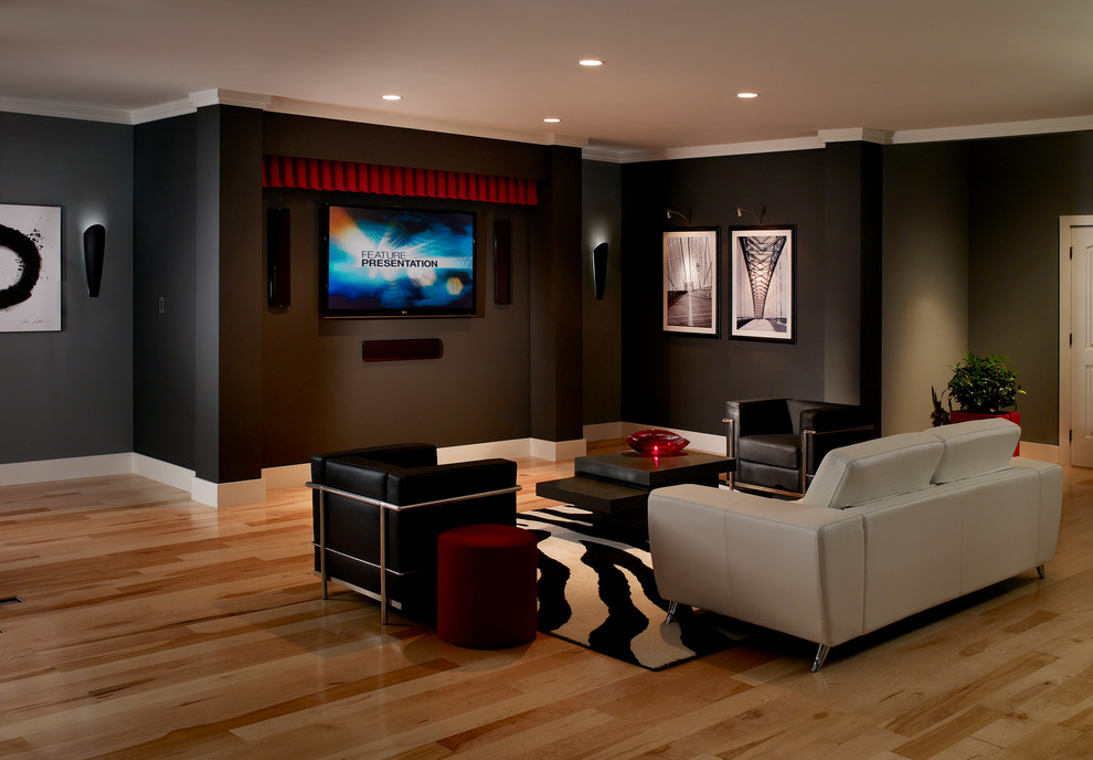 Стильный дизайн: открытый домашний кинотеатр среднего размера в стиле неоклассика (современная классика) с черными стенами, паркетным полом среднего тона, телевизором на стене и коричневым полом - последний тренд