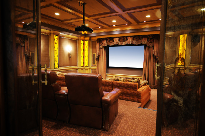 Modelo de cine en casa cerrado clásico grande con paredes marrones, moqueta y pantalla de proyección