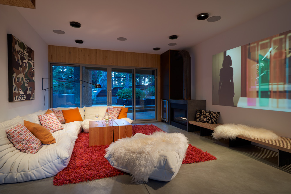 Ejemplo de cine en casa actual con paredes blancas, suelo de cemento, pantalla de proyección y suelo gris