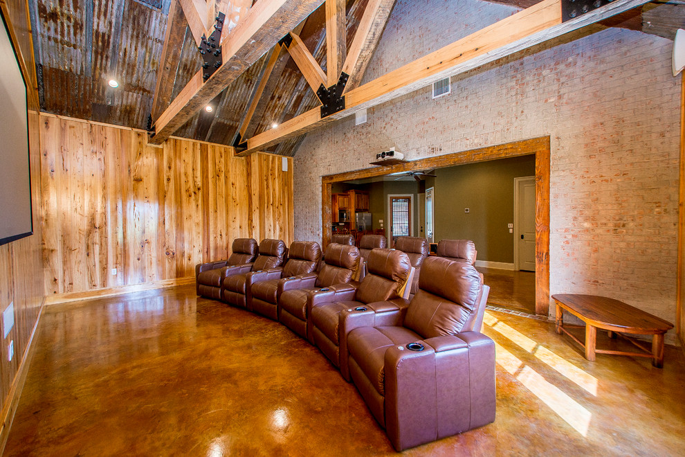 Expansive rustic enclosed home cinema in New Orleans with brown walls, concrete flooring and a projector screen.