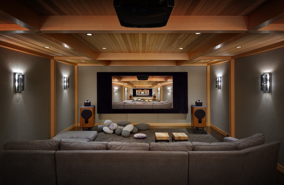 Cette image montre une salle de cinéma chalet fermée avec un mur gris, moquette, un sol gris et un écran de projection.