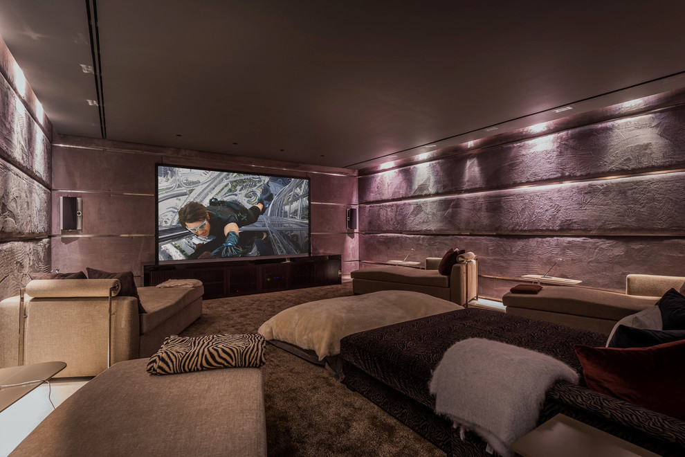 Cette image montre une grande salle de cinéma design fermée avec un mur violet et un téléviseur encastré.