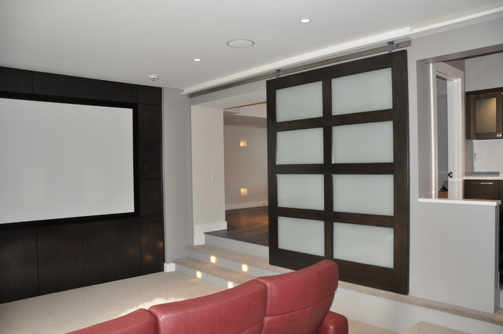 Large trendy enclosed carpeted and beige floor home theater photo in Boston with white walls and a projector screen