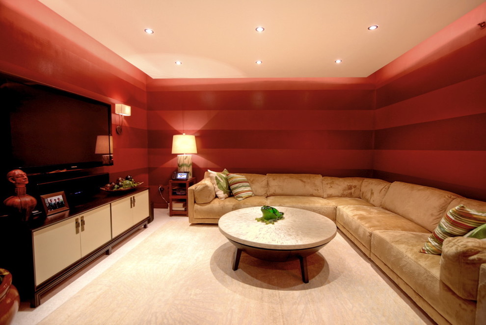 Modern inredning av ett mellanstort avskild hemmabio, med röda väggar och en väggmonterad TV