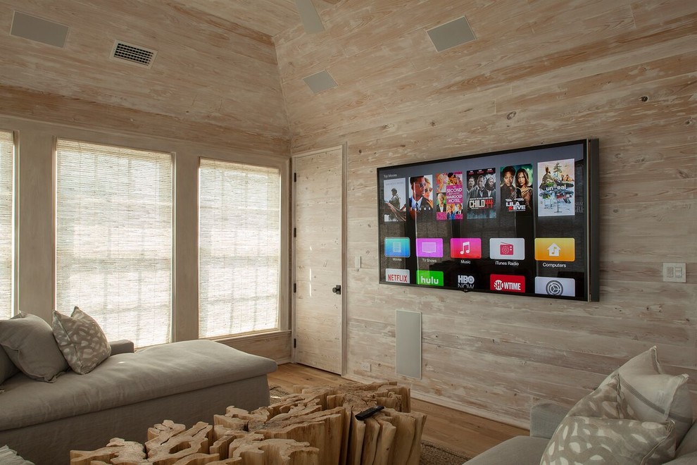 Imagen de cine en casa cerrado minimalista grande con suelo de madera clara, televisor colgado en la pared, suelo naranja y parades naranjas