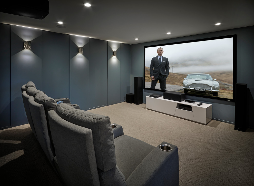 Ejemplo de cine en casa actual con paredes grises, moqueta, pantalla de proyección y suelo gris