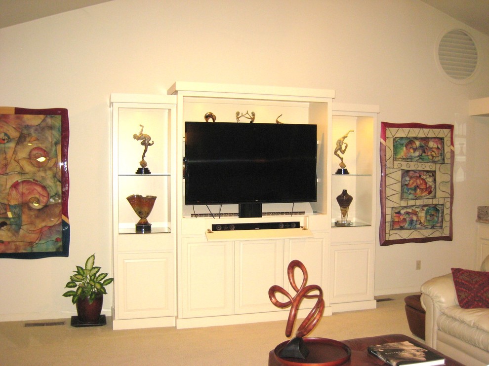 Foto på ett stort funkis öppen hemmabio, med vita väggar, heltäckningsmatta och en inbyggd mediavägg