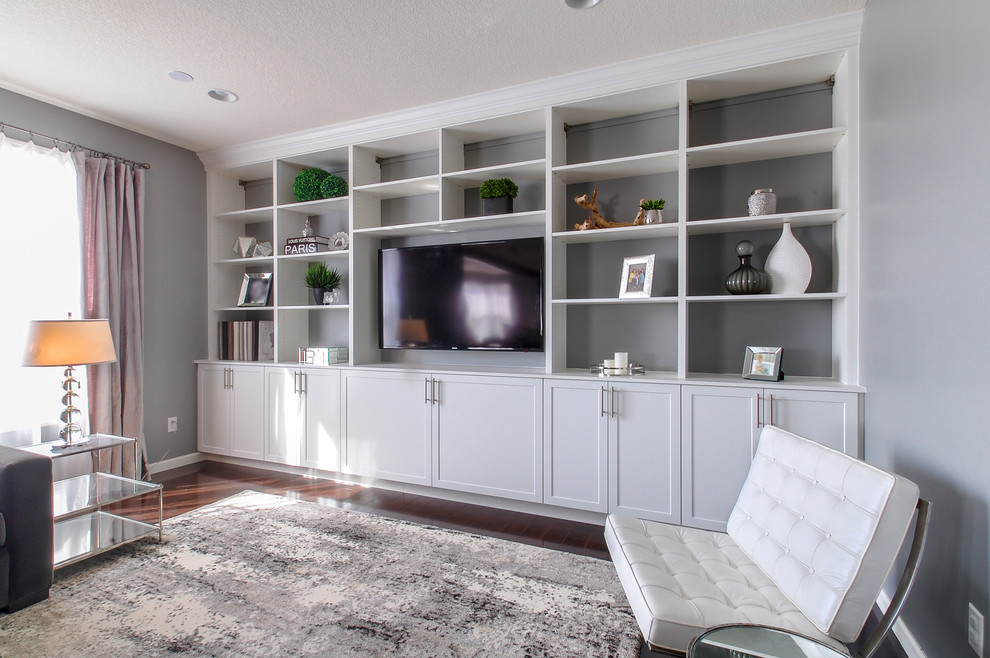 This is an example of a large contemporary open plan home cinema in Minneapolis with grey walls, dark hardwood flooring and a built-in media unit.