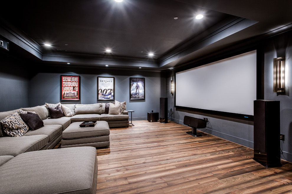 На фото: большой открытый домашний кинотеатр в стиле кантри с синими стенами, паркетным полом среднего тона и проектором с