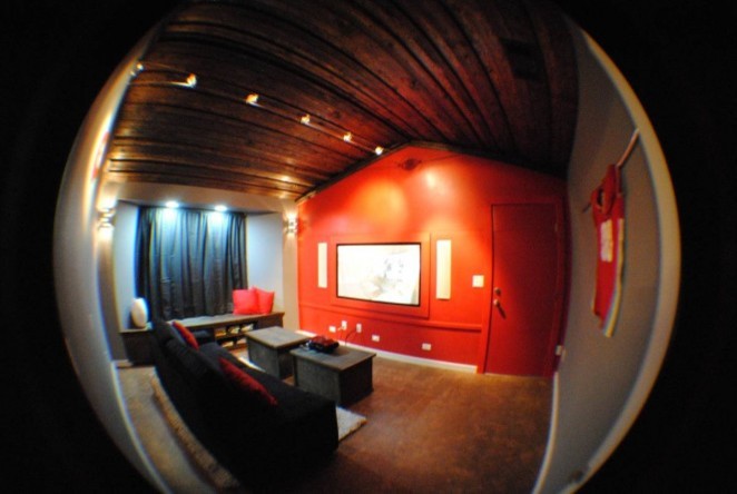 Modelo de cine en casa cerrado minimalista de tamaño medio con paredes rojas, suelo de corcho y pantalla de proyección