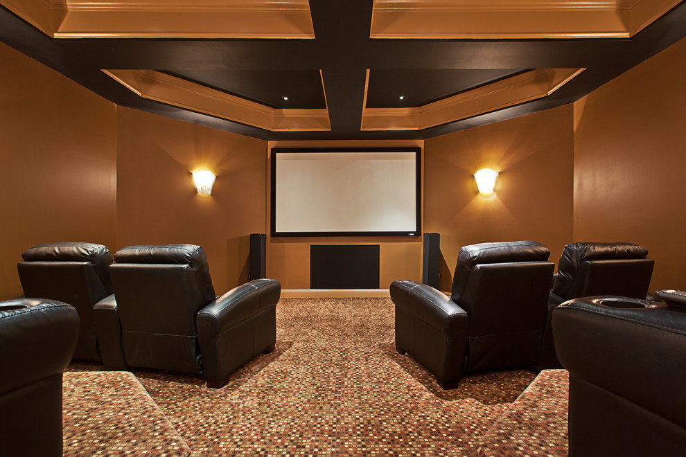 На фото: изолированный домашний кинотеатр в классическом стиле с коричневыми стенами, ковровым покрытием, проектором и разноцветным полом с