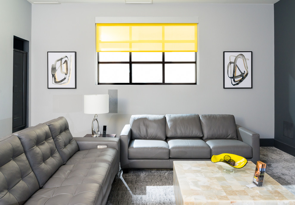 Modern inredning av ett hemmabio, med grå väggar, heltäckningsmatta, projektorduk och grått golv