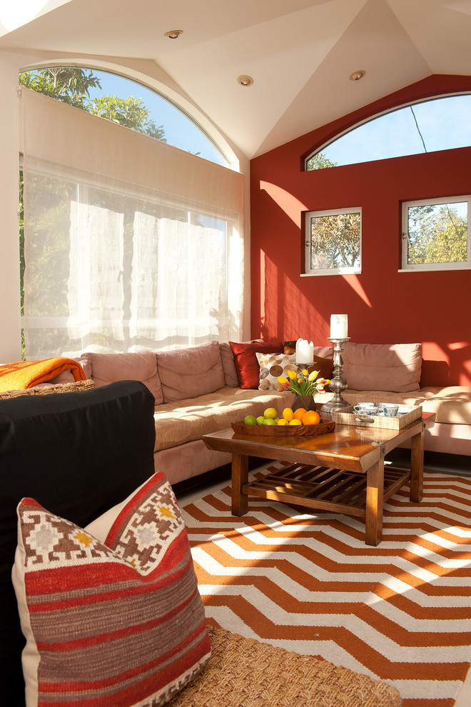 Example of a mid-sized eclectic open concept limestone floor and beige floor home theater design in San Francisco with red walls