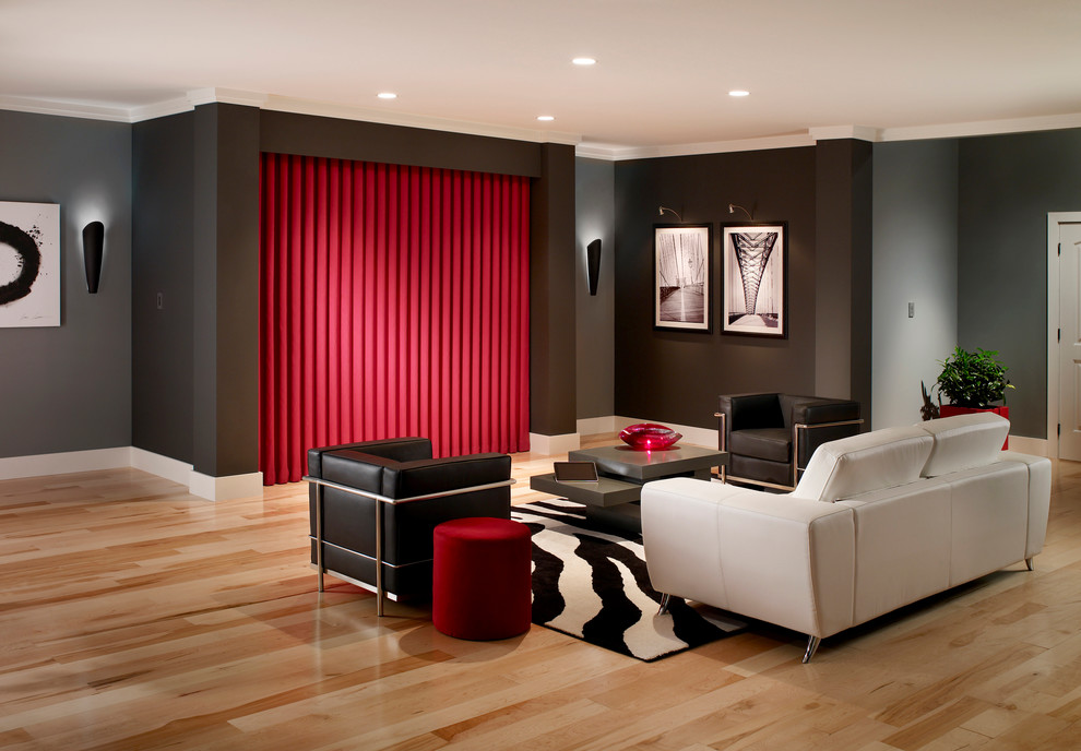 Diseño de cine en casa abierto contemporáneo de tamaño medio con paredes grises, suelo de madera clara y televisor colgado en la pared