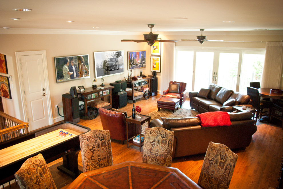 Imagen de cine en casa tradicional con paredes beige, suelo de madera en tonos medios y televisor colgado en la pared