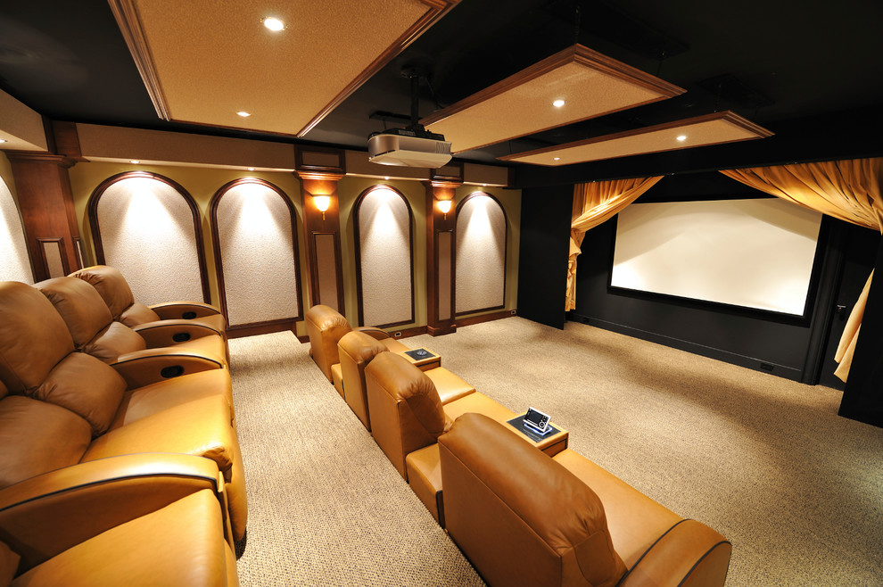 На фото: большой изолированный домашний кинотеатр в стиле неоклассика (современная классика) с бежевыми стенами, ковровым покрытием, проектором и коричневым полом