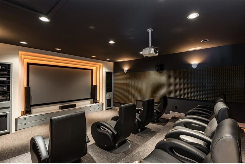 Пример оригинального дизайна: большой изолированный домашний кинотеатр в стиле модернизм с черными стенами, ковровым покрытием, проектором и серым полом