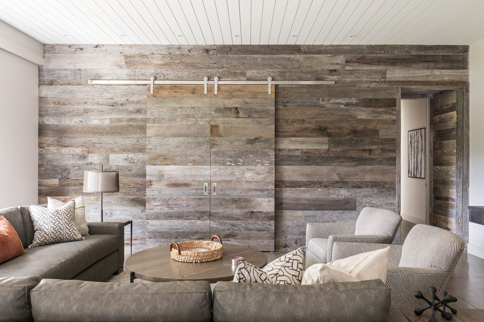 Foto på ett stort lantligt öppen hemmabio, med vita väggar, betonggolv, en inbyggd mediavägg och grått golv