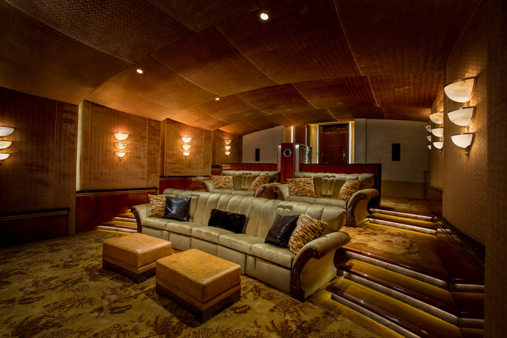 Стильный дизайн: изолированный домашний кинотеатр в средиземноморском стиле с оранжевыми стенами, ковровым покрытием, проектором и разноцветным полом - последний тренд