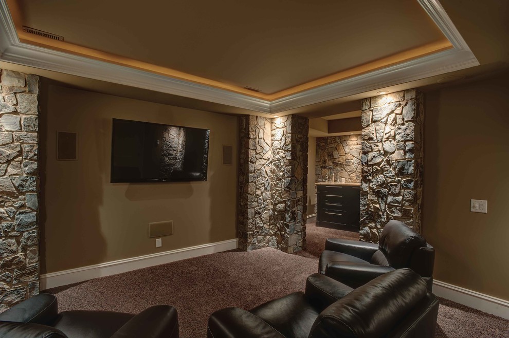 Imagen de cine en casa abierto tradicional con paredes beige, moqueta y televisor colgado en la pared