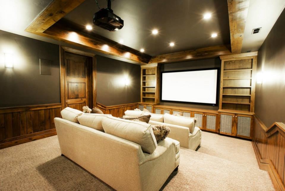 Пример оригинального дизайна: большой изолированный домашний кинотеатр в стиле рустика с зелеными стенами, ковровым покрытием, проектором и бежевым полом