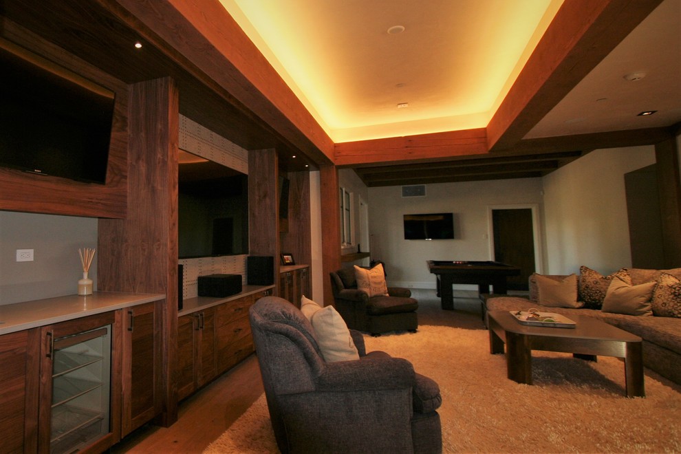 Ejemplo de cine en casa abierto contemporáneo grande con suelo de madera clara, televisor colgado en la pared, suelo marrón y paredes azules
