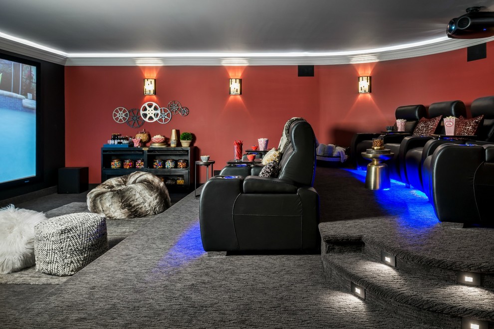 This is an example of a classic enclosed home cinema in Toronto with red walls, carpet and a projector screen.