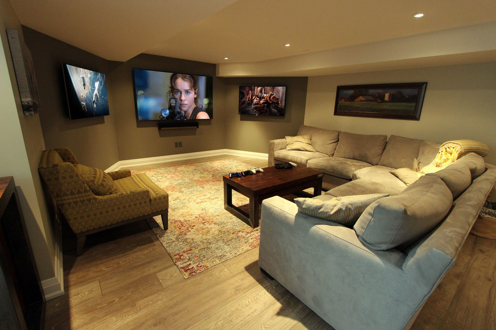 Foto de cine en casa abierto clásico de tamaño medio con paredes beige, suelo laminado, televisor colgado en la pared y suelo marrón