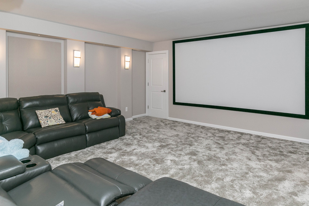 Идея дизайна: большой изолированный домашний кинотеатр в современном стиле с серыми стенами, ковровым покрытием, проектором и серым полом