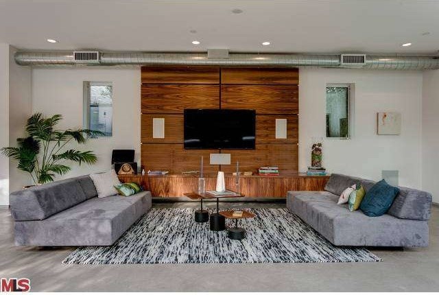 Mittelgroßes, Offenes Modernes Heimkino mit weißer Wandfarbe, Betonboden und TV-Wand in Los Angeles